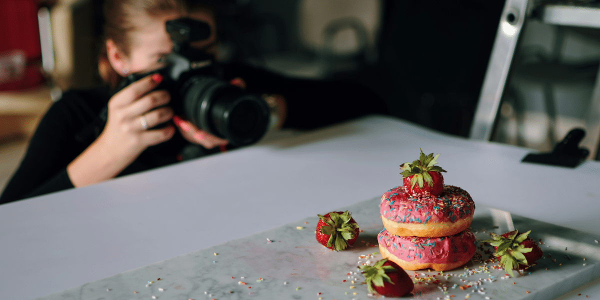 photographer taking a picture of a donut in the table